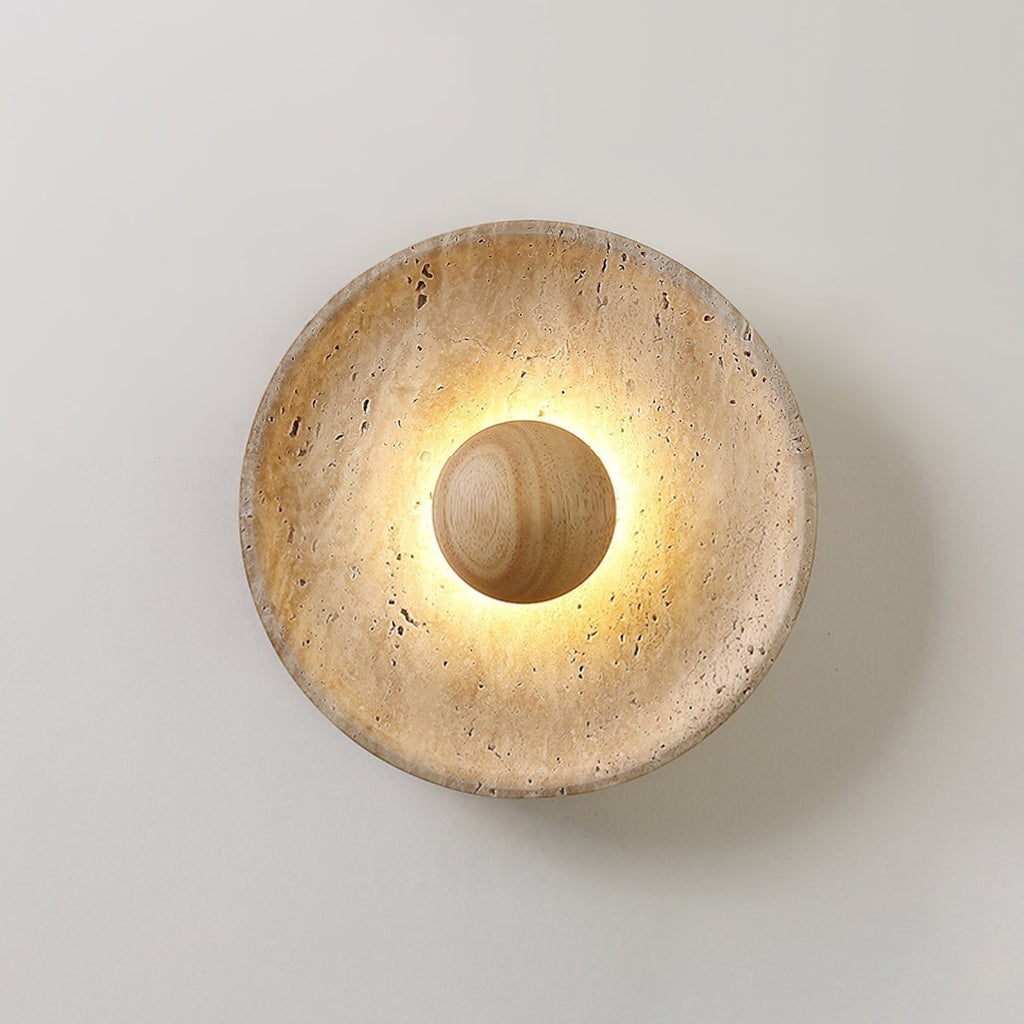 Lumiris sculptural wall light in travertine and wood, warm light diffused around a central sphere.